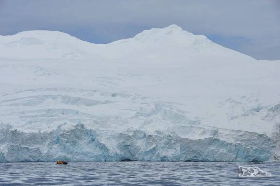 Um zodiac e seus passageiros quase desaparecem perto da imensidão gelada de Point Wild, em Elephant island, na Antártida